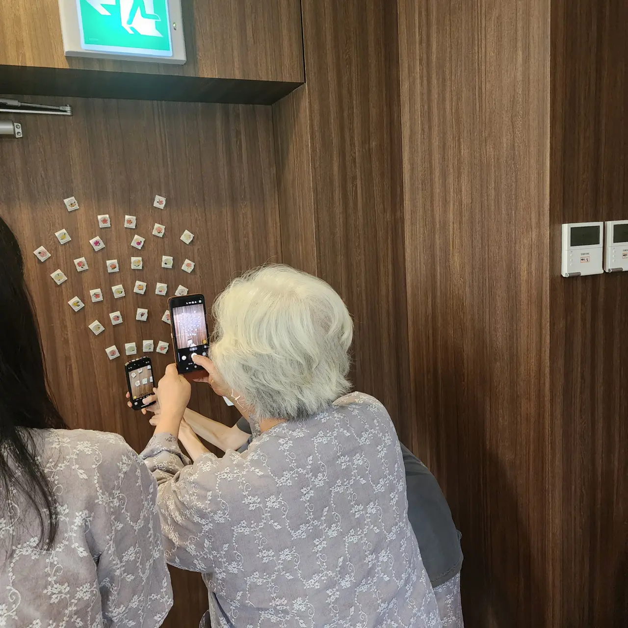 완성한 압화 마그넷을 벽에 붙이고 사진을 찍는 모습