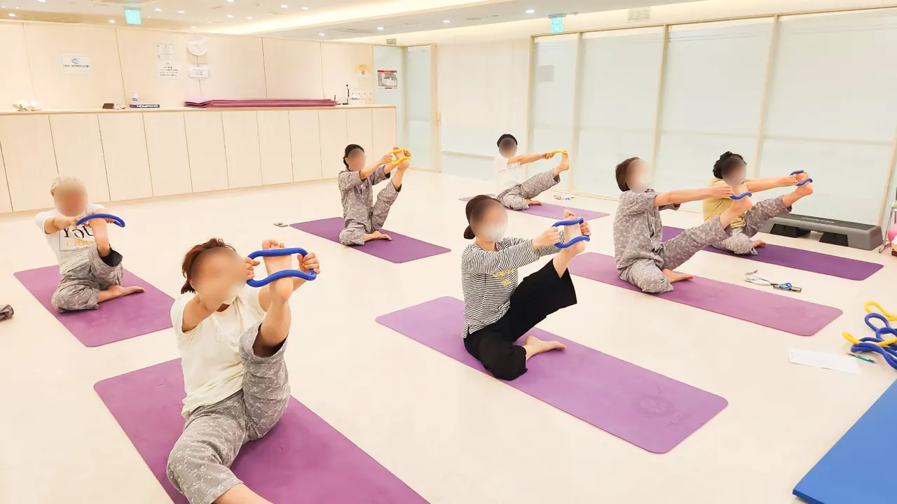 GX룸에서 스트레칭 링으로 다리를 늘리는 모습