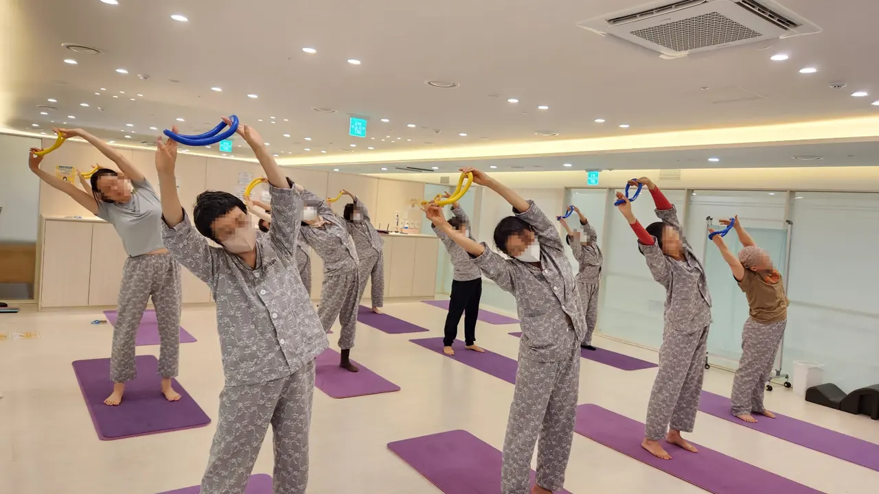스트레칭 링을 들고 옆구리를 늘리는 모습